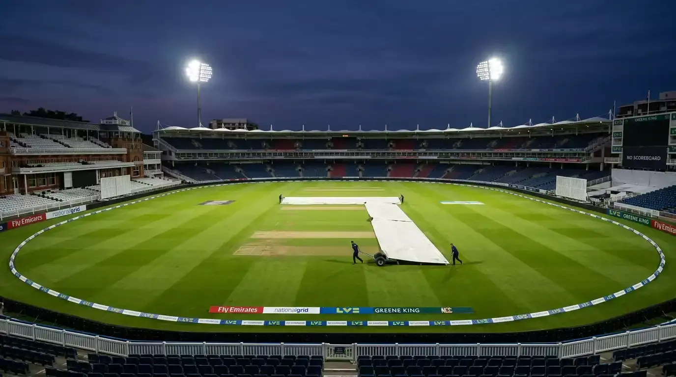 Empty cricket stadium under floodlights moments before the toss with covers being rolled off the pitch